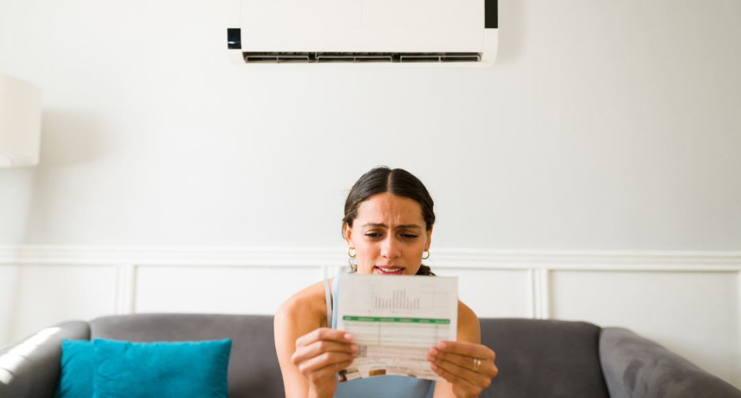 mørkhåret pige der sidder i sofa og kigger undrende på sin elregning, fordi hun ikke ved, hvad en elafgift er